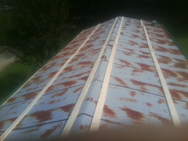 Rusted metal roof panels with new wood purlins before replacement — Storm Damage Roof Repair in Yarmouth Port by Roofing Brothers