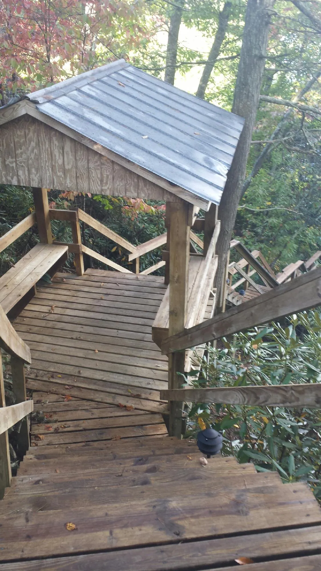 Metal roofed shelter over wooden steps on a wooded walkway — Skylight Repair & Installation work by our crew in Yarmouth Port