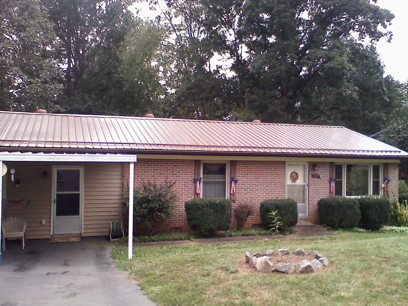 Bronze metal roof and carport on a brick ranch home — Roof Repair work by our crew in Yarmouth Port